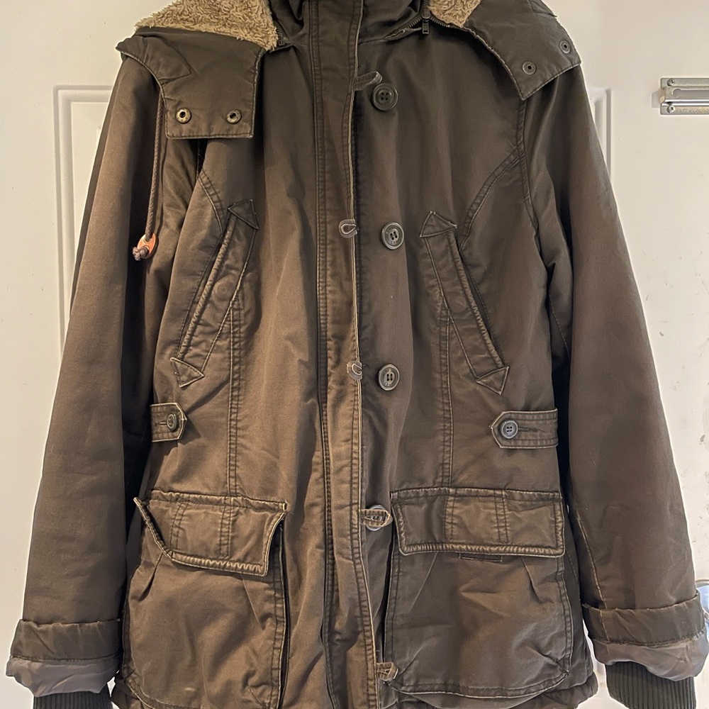 Multi-pocket heavy jacket with zipper hood and faux fur lining. Women’s size 12